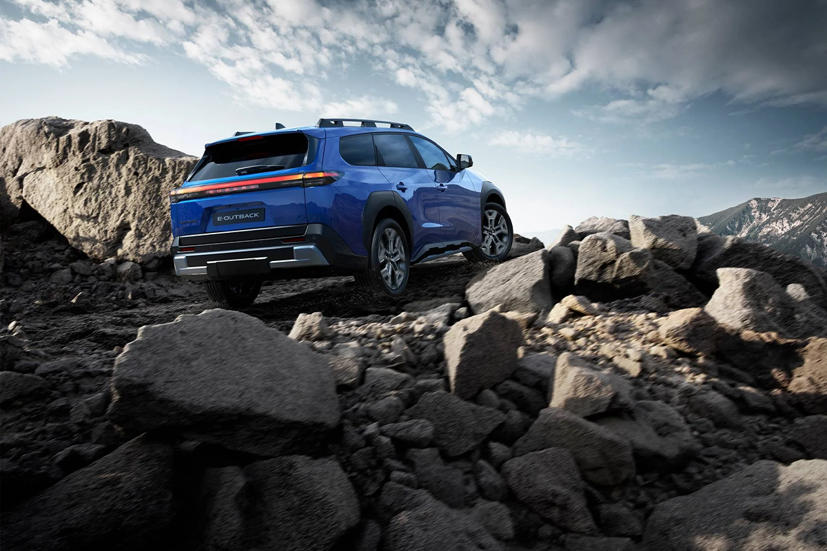 ein blauer E-Outback im Gelände unterwegs auf einen steinigen Pfad.
